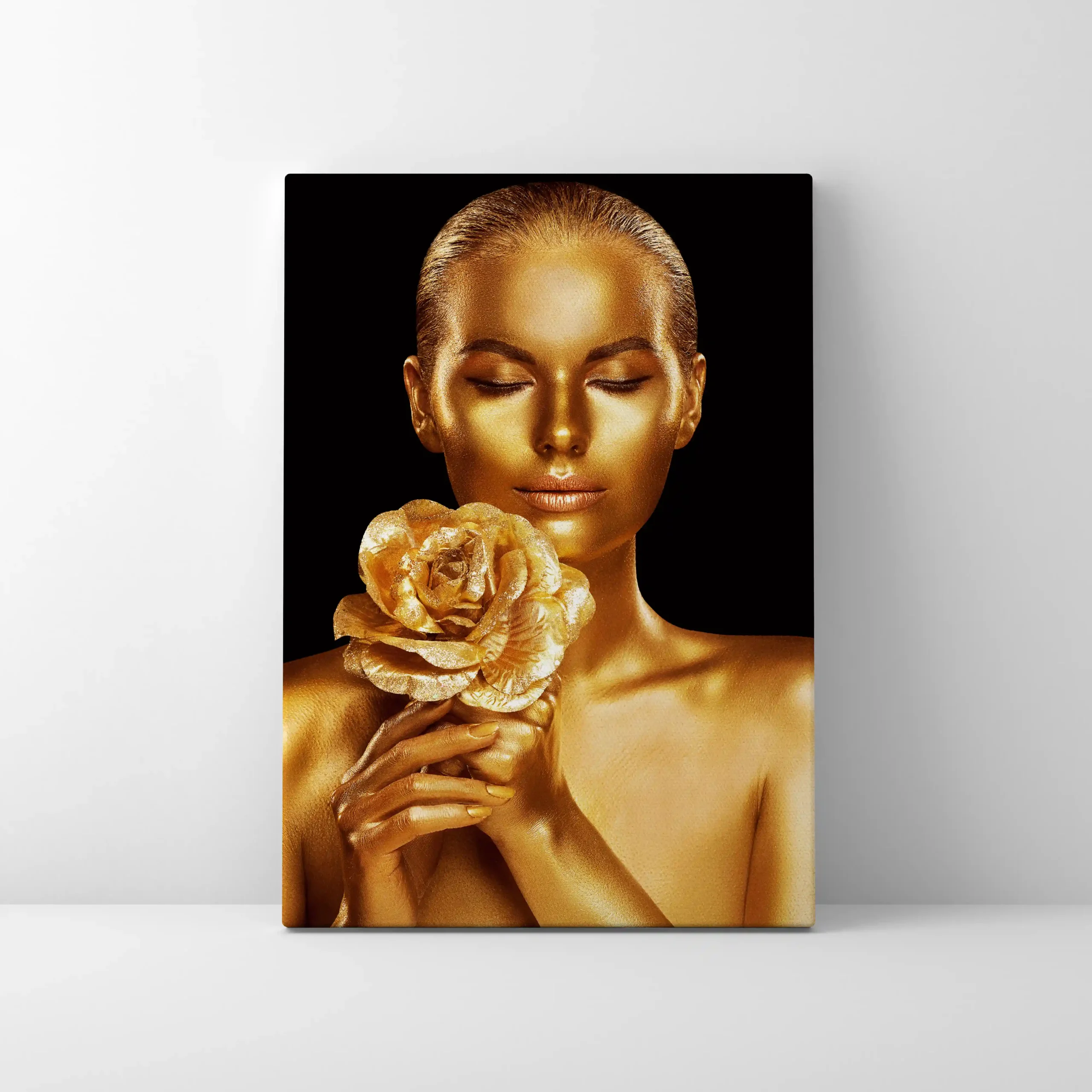 Abstract portrait of a woman with gold body paint and golden rose.